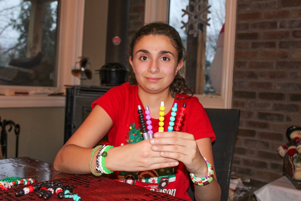 Mia DeRose, 10, shows off some of her handiwork her craft business CL Looms. She used proceeds from the sales of her bracelets, pens and more to purchase toys which she donated to Pelham Cares.
