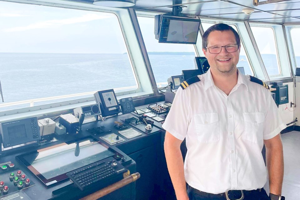 Second office Lawrence Hartwick stands next to radar equipment on the MS Chi-Cheemaun. 