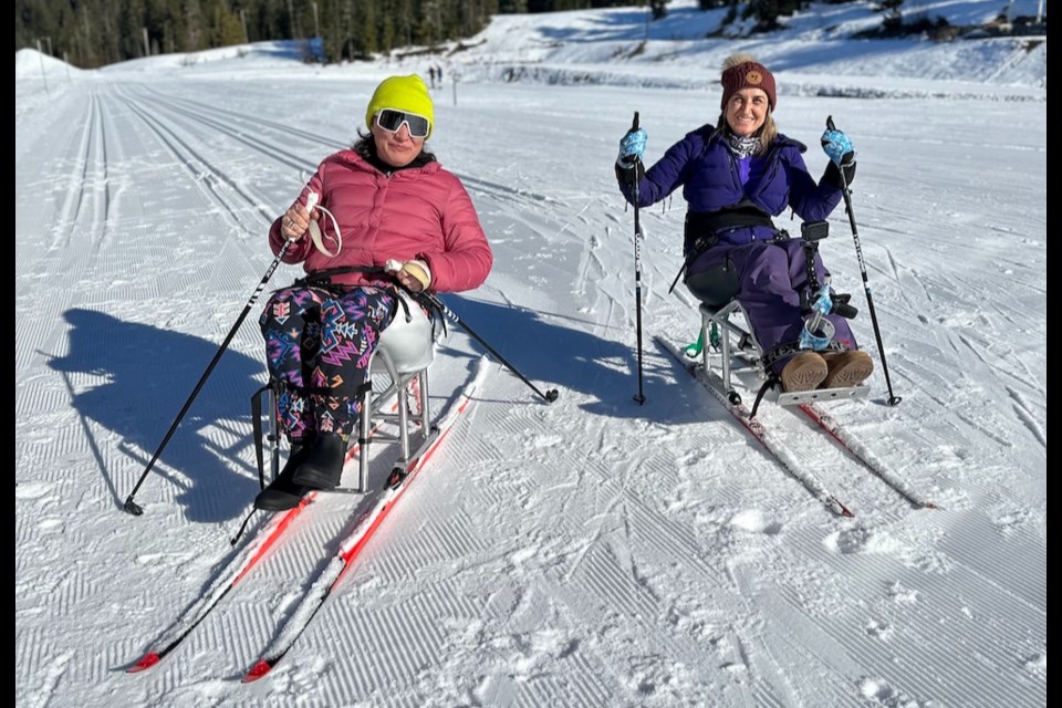 Christa Couture (left) tries sit-skiing beside Whistlerite Olivia Rey.