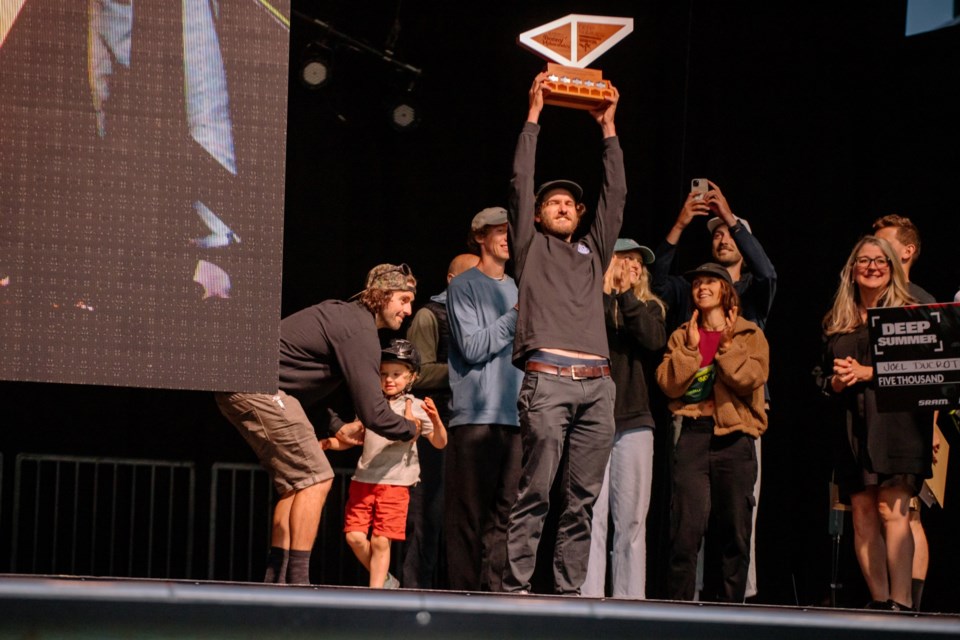 Joel Ducrot raises his trophy at the 2024 Deep Summer Photo Challenge.