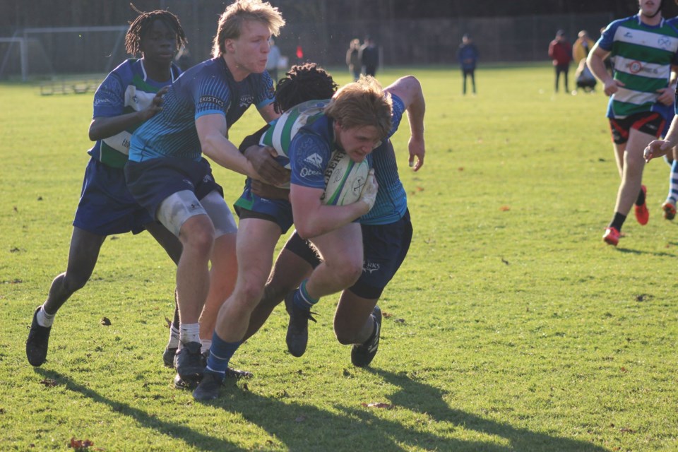 An Axemen ball carrier attempts to break a tackle during U18 Gold League action against Bayside Sharks RFC.