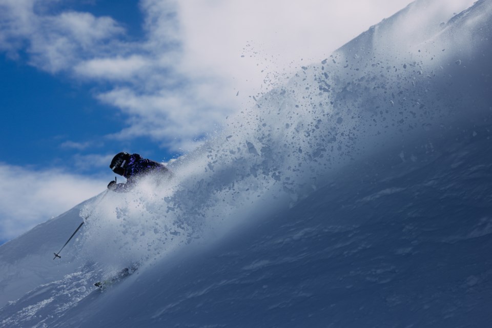 Kayla Constantini throws up powder on the mountain.