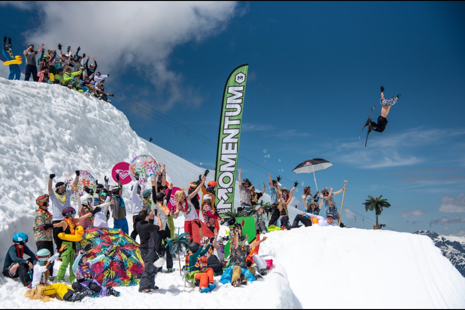 A Momentum Camps skier goes airborne while many of his peers and coaches cheer him on during a 2019 session.