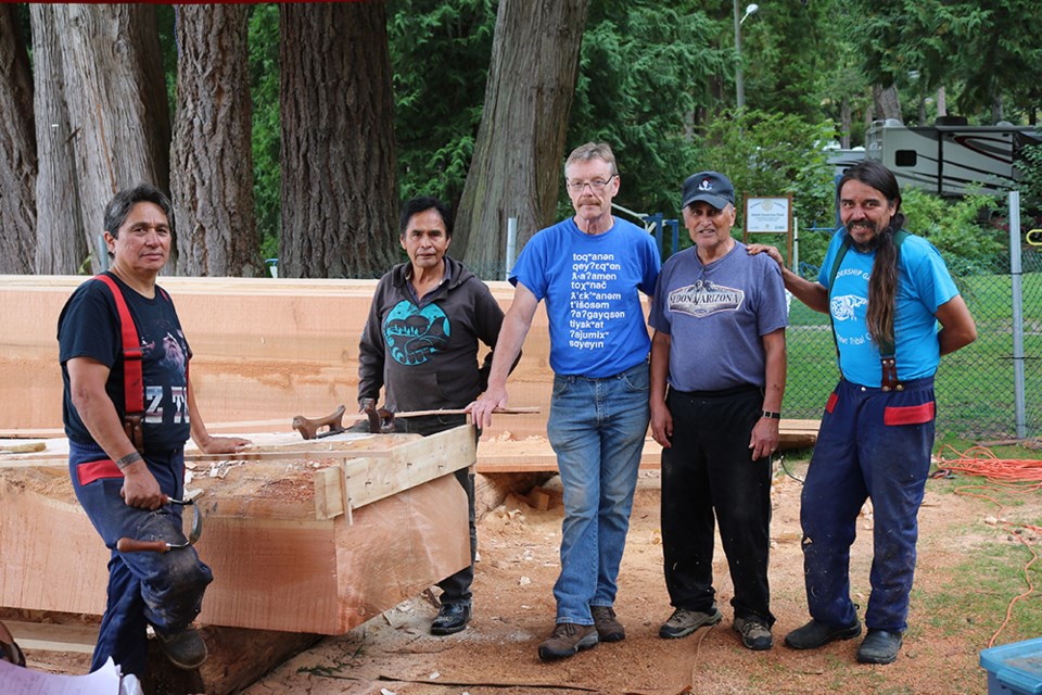 RESHAPING LOG: Carvers at the Hɛhɛwšin (the way forward) reconciliation canoe journey project in 2017 at Willingdon Beach were [from left]: Sherman Pallen, master carver Joe Martin, Phil Russell, Tla’amin Nation elder Alvin Wilson and Ivan Rosypskye. Martin will be returning to the qathet region on August 5 to highlight a book he has co-written on canoe carving, including a chapter on the Hɛhɛwšin project.