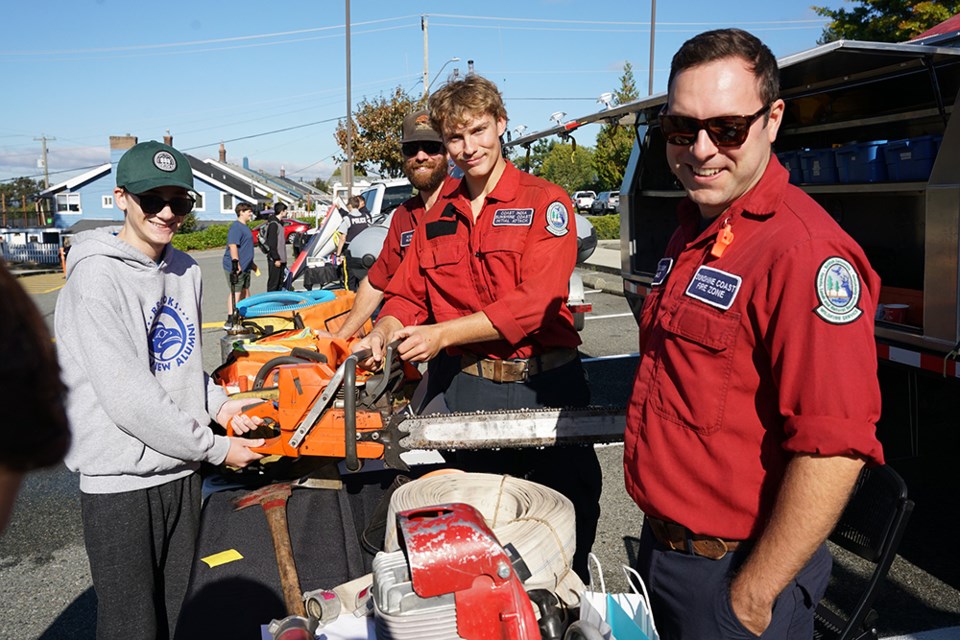 FUTURE JOBS: Brooks Secondary School grade nine student Liam Pinch [left] hears about career prospects from initial attack firefighters [from left] Peter Milner, Jake Hollinshead and Gregory Blais at a recent career fair. The school’s parking lots were crammed with exhibitors, who provided students with information about their businesses or organizations, and career opportunities.                               