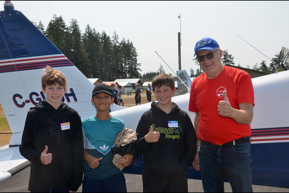 Students at the annual Texada AeroSpace Camp [from left] Ethan Bowman, Vance Mckleen Dumelod and Lochlann Clark gave a thumbs up for pilot Sylvain Fortin [right] after a familiarization flight in his Cherokee 180 aircraft.