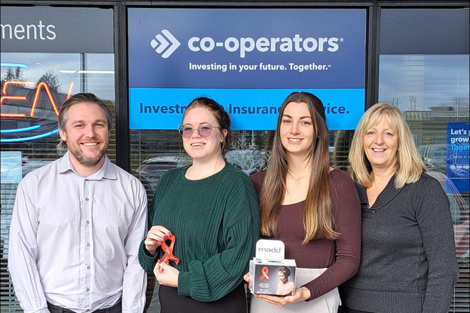 HELPING OUT: Staff at the Co-operators insurance agency show a red ribbon and a donation box from the Project Red Ribbon campaign launched by Mothers Against Drunk Driving.