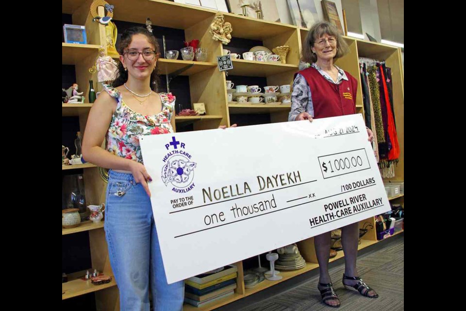 Powell River Health-Care Auxiliary Sue McCallum [right] presents the first half of a $2,000 scholarship to Noella Dayekh.