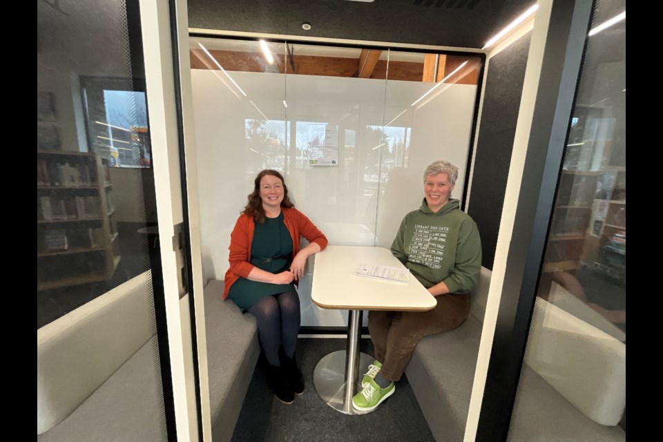 SILENT POD: Powell River Public Library chief librarian Rebecca Burbank [left] and accessibility coordinator Karen Wootten sit in a recently acquired silent study/meeting pod. The sound-reducing pod is one part of the library's ongoing accessibility improvements. 
