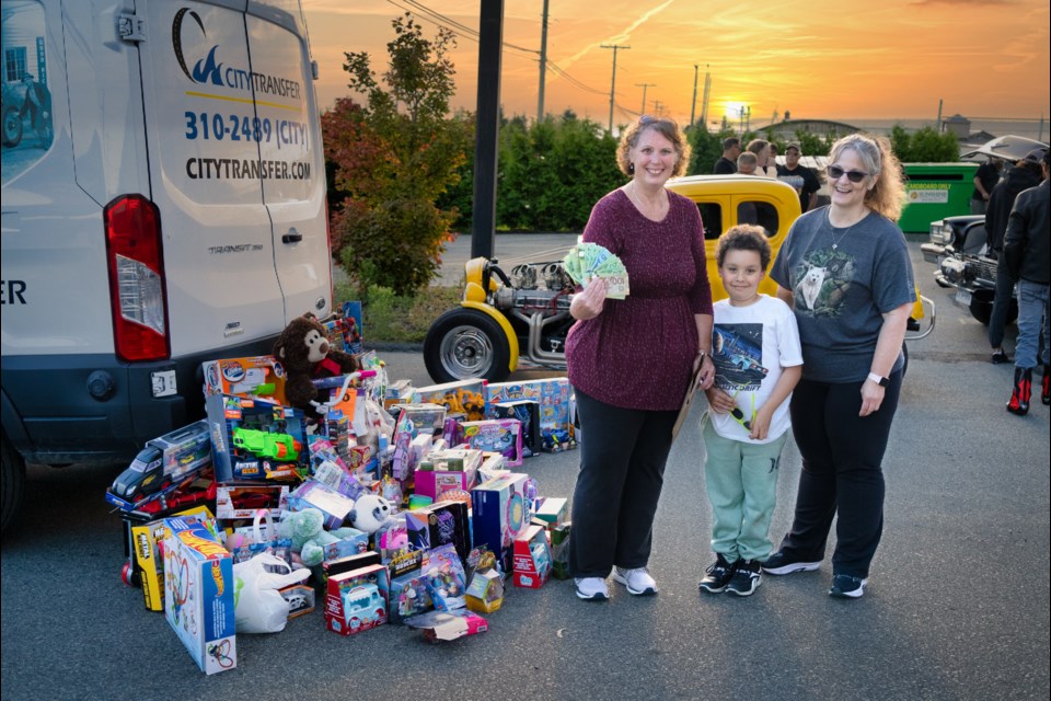 CHRISTMAS CHEER: Volunteers Laura Passek [left], Dominic Sparks and Wendy Rideout show off the generous donations given at the 7th annual Super Dave Rod Run/Toy Run. The fundraiser and toy drive was organized by Steve Bartfai in honour of his friend Dave Pearson, nicknamed “Super Dave” and took place, Wednesday, September 6.
