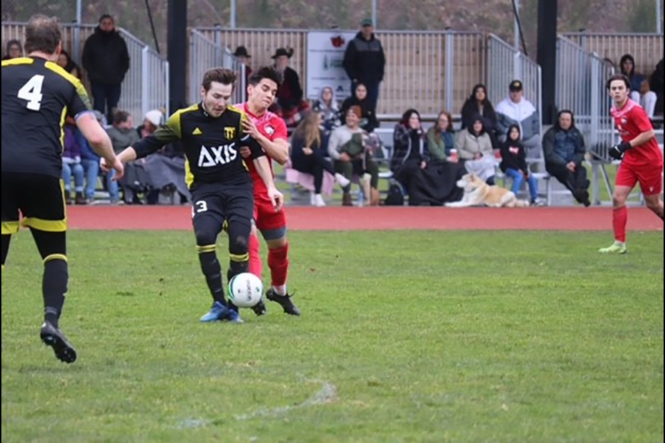 Jarod Timothy [in red, crowding a Cowichan FC opponent during a VISL match last season], took the shot that resulted in the winning goal scored by his Powell River Villa teammate Casper Poelen last weekend at Timberlane Park.