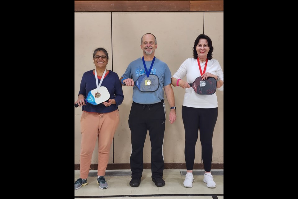 PODIUM PLACEMENTS: Gherkin pickleball gold medalist Gerry Anderson [centre] with silver medalist San Raubenheimer [right] and assistant referee Xóchitl Hernández [left], who accepted the bronze medal on behalf of Richard Clark [not pictured].