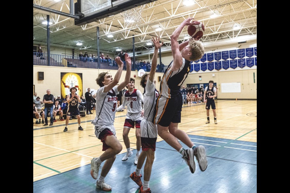 Nechako Valley Vikings forward Zeke Ferguson jumps up to take a shot as D.P. Todd Trojans try to block him in their North Central zone double-A semifinal Friday, Feb. 21, 2025 at D.P. Todd Secondary School.