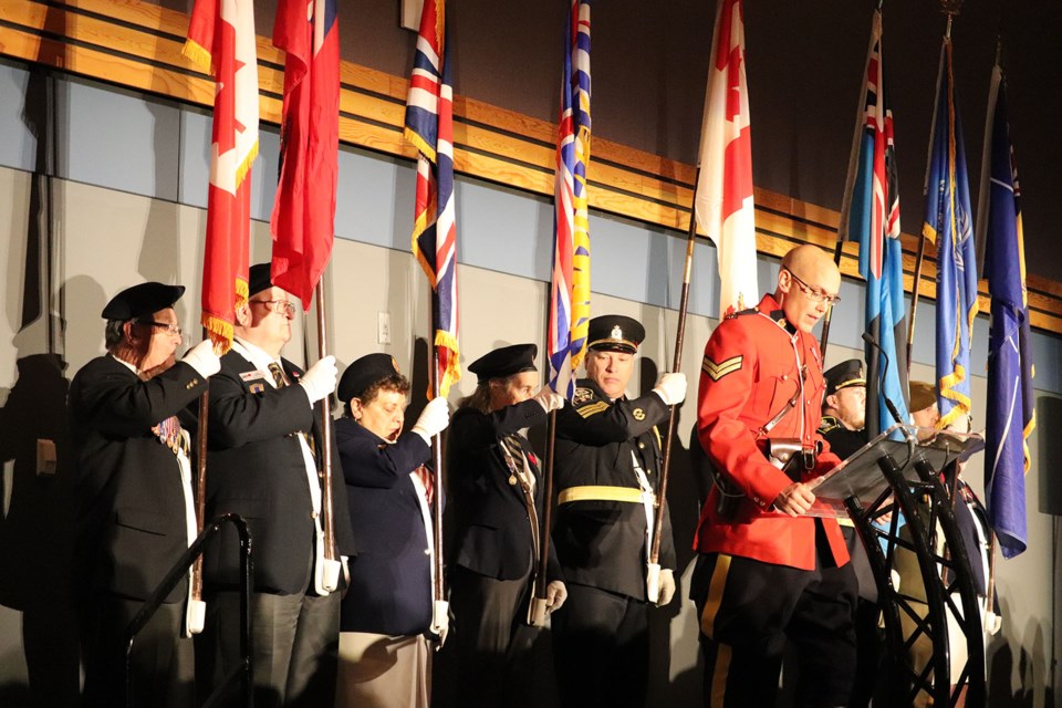 Cpl. Craig Douglass speaks in front of the Colour Guard. (via Hanna Petersen)