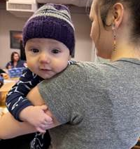  A baby wears one of the handmade caps given out as part of the Click for Babies program. More than 800 caps will be handed out to parents and caregivers of newborns and 2-month-old infants from now until the end of February.