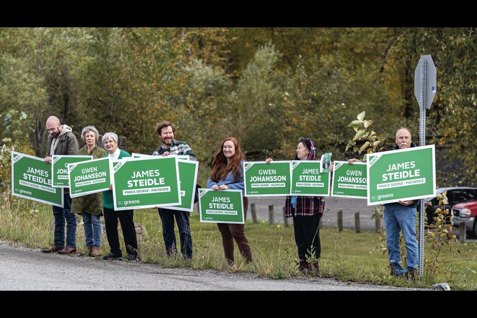 BC Greens supporters, including MLA candidates Gwen Johansson and James Steidle, wave campaign signs  on River Road at the launch of the BC Greens Campaign Thursday at Cottonwood Island Park.