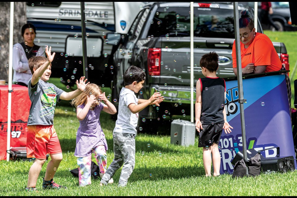 Kids found some fun away from the stage as they played in a shower of bubbles from a bubble maker at the CKPG booth taking part in Canada Day celebrations at Lheidli T'enneh Memorial Park Monday.