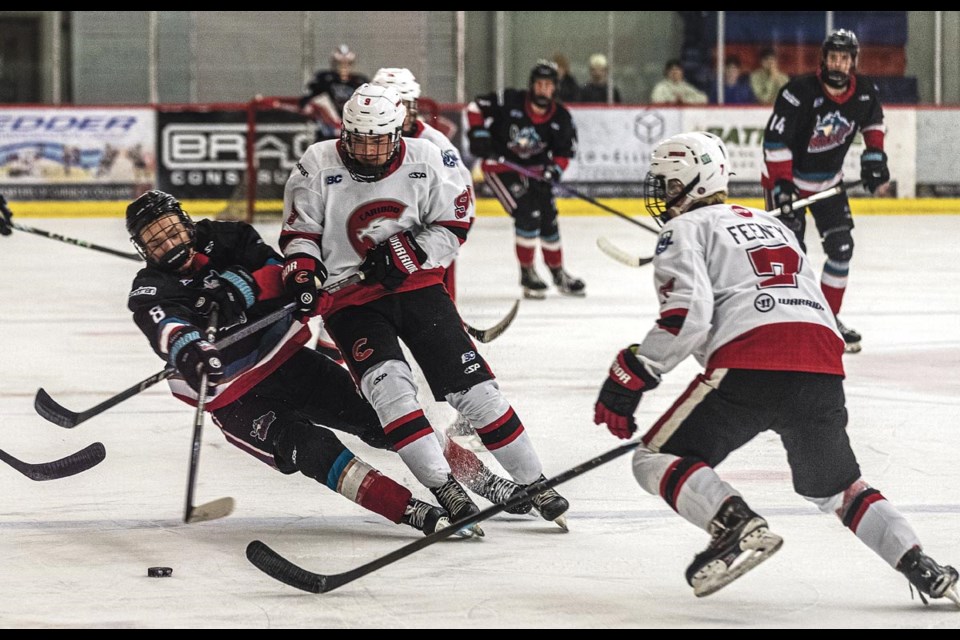 Rockets defenseman Kylen Martens and  Cariboo Cougars forward Lucas Woodstock tangle up as they fight to reach the puck Saturday, March 22, 2025 at Kin 1.