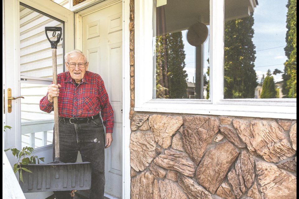 Hundred-year-old Carl Aastrup holds up the shovel that was used to break his window and door handle during a March 2022 home invasion attempt.