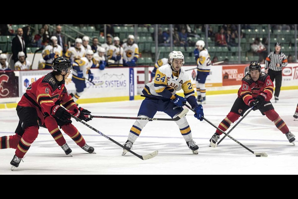 Saskatoon Blades defenseman #24 Tanner Molendyk feels the pressure as three Cougars close in on him at CN Centre Tuesday.