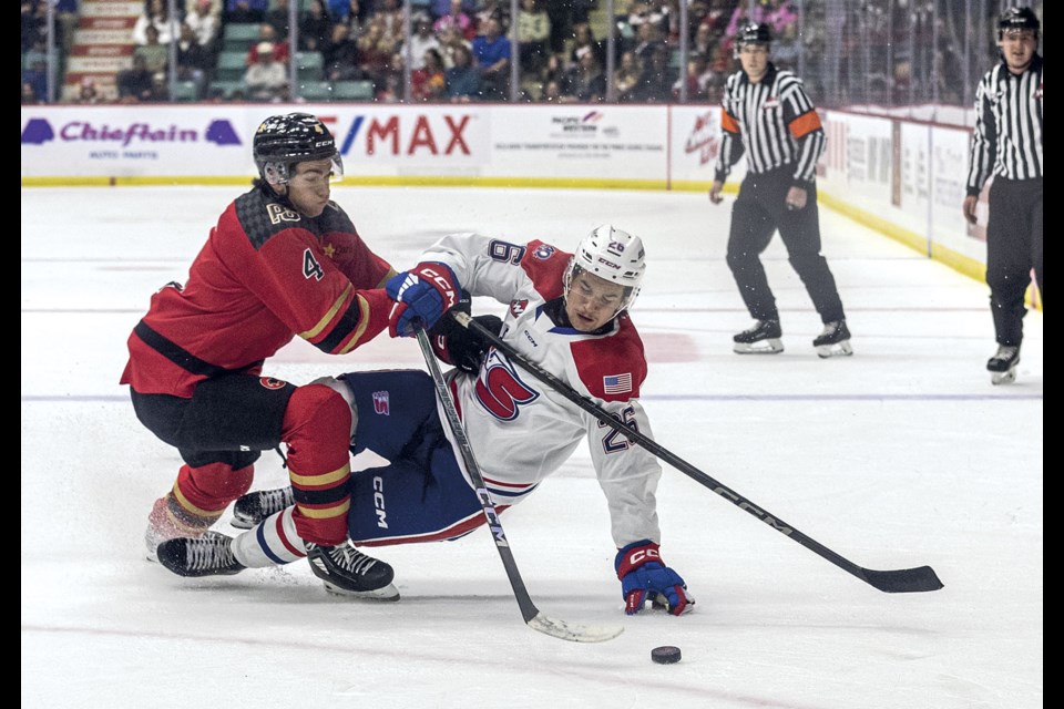 Cougars defenseman #4 Carson Carels takes Chiefs #26 Chase Harrington off the puck during first period action of  the season home opening game at CN Centre Friday.