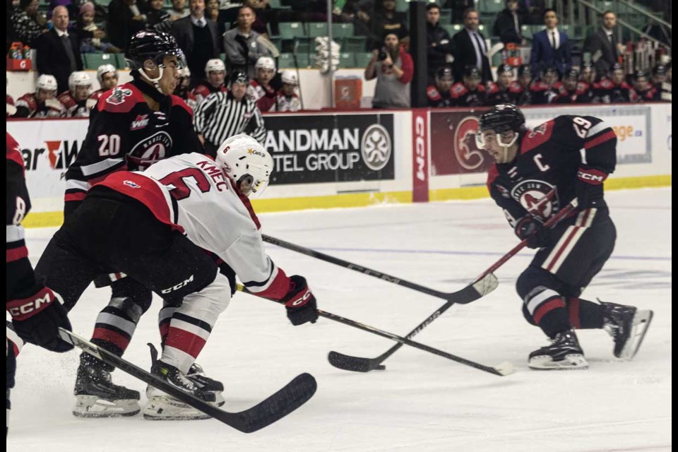 Cougars defenseman #6 Viliam Kmec forces Moose Jaw Warriors forward #20 Pavel McKenzie out of the way as he rushes forward #29 Braden Yager Tuesday at CN Centre.