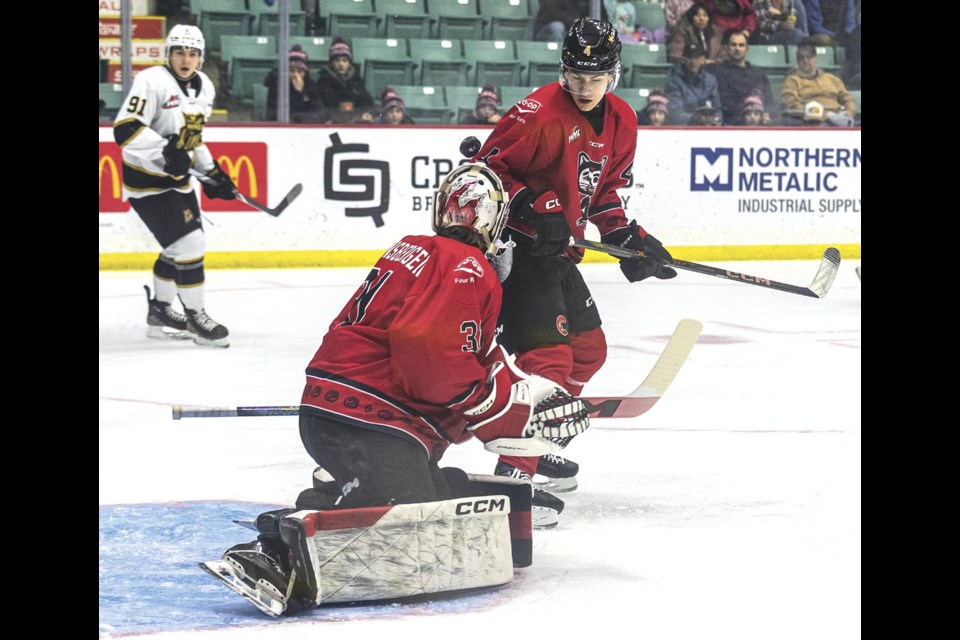 Cougars goalie Josh Ravensbergen and defenseman Carson Carels watch the puck as it deflects up over Ravensbergen's shoulder in their game against the Brandon Wheat Kings at CN Centre January 24.