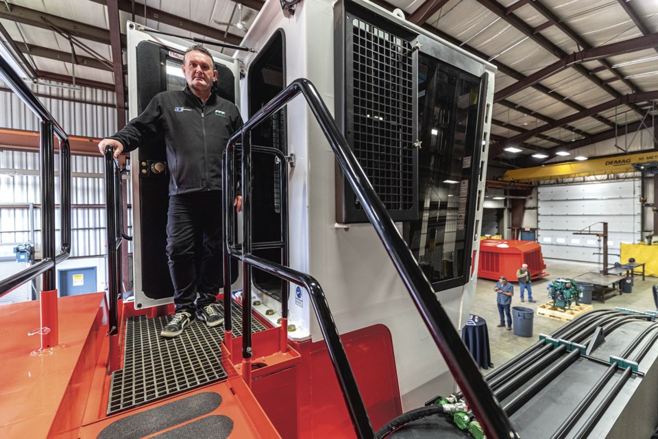 Dale Ewers stands just outside the cab of the Madill 3000B log loader at the unveiling of the new Madill manufacturing facility DC Equipment on Otway Road Friday.