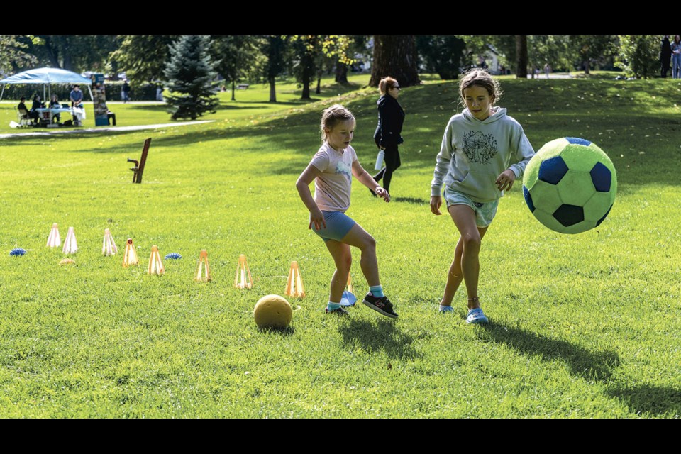 Lillian Rawlings, 6, and Ella Parks, 11, take some of the balls, cones and hoops they found at the Engage Sport North booth to create an obstacle course that kept them happy for a while attending the Fall Active Living Market in the Park event Saturday at Lheidli T'enneh Memorial Park. More information on the programs Engage Sport North offers can be found at  their website https://engagesportnorth.com/.