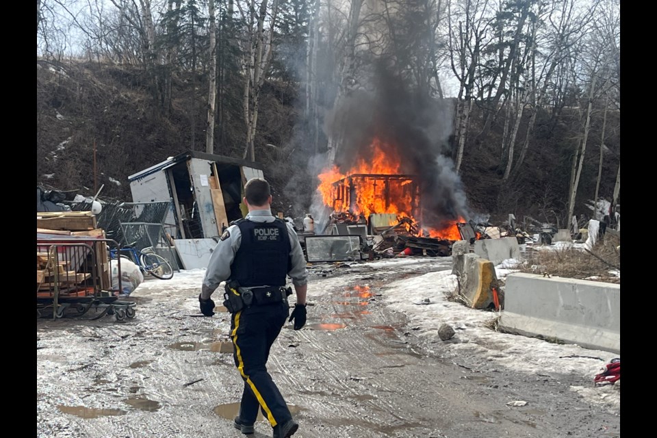 An RCMP officer heads to the scene of a structure fire at Moccasin Flats on Thursday, March 20, 2025 in Prince George, BC.