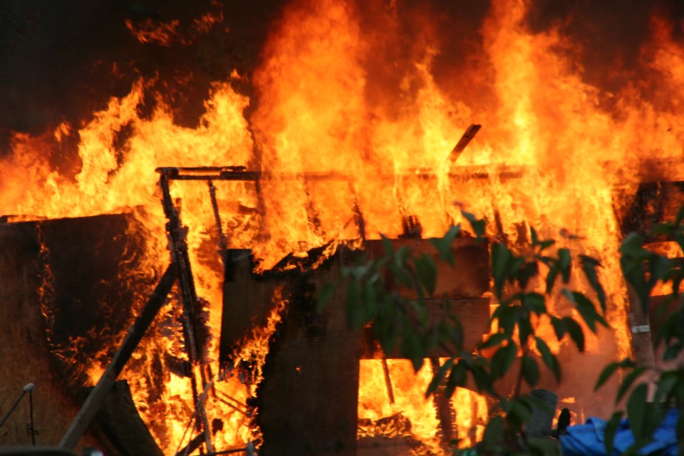 Firefighters battle a blaze at Moccasin Flats in Prince George, BC on Wednesday, Sept. 25, 2024.