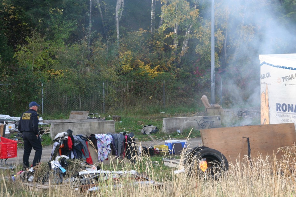 City firefighters put out a small fire at Moccasin Flats on Friday, Sept. 27, 2024 in Prince George, B.C. The fire was confined to some debris on the ground outside one of the temporary shelters in the encampment.