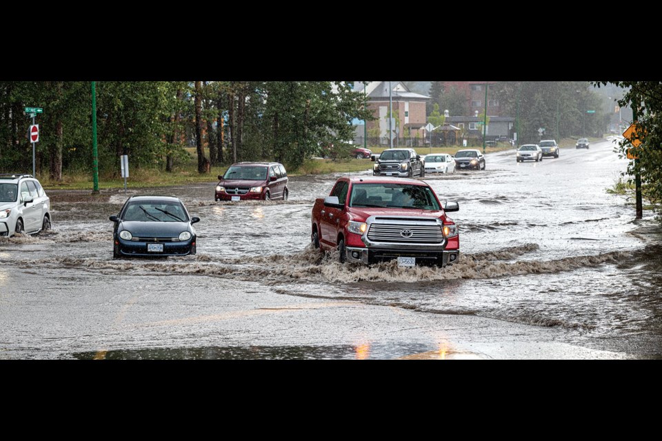 Vehicles line up as they decide whether to attempt to pass through floodwater at 15th Avenue and Winnipeg Street on Thursday afternoon.