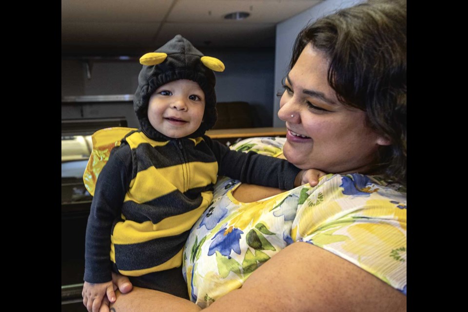 Hunter Popovits, 17 months, is dressed up as a busy bee at the Halloween Festival at the Northern Sports Centre with Latisha Banotra Saturday, Oct. 26.