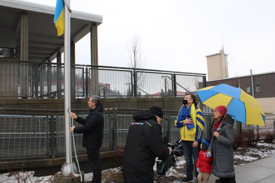 Father Andrii Chornenkyii of the Ukrainian St. George's Catholic Church raises the Ukrainian flag at Prince George City Hall on Tuesday, as local members of the Ukrainian -Canadian community sing the Ukrainian national anthem.