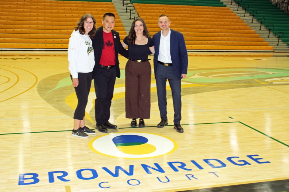 The new hardwood floor at the Northern Sport Centre's newly-named Brownridge Court was unveiled Friday morning. From left are UNBC atheltics director Loralyn Murdoch, Mayor Simon Yu, Emily Holmes of Brownridge Insurance and UNBC president Geoff Payne