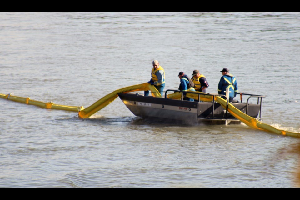 First responders from Swat Consulting Inc., connect an oil containment boom in the Fraser River adjacent to Lheidli T'enneh Memorial Park last week as part of Pembina Pipeline's emergency management training exercise.