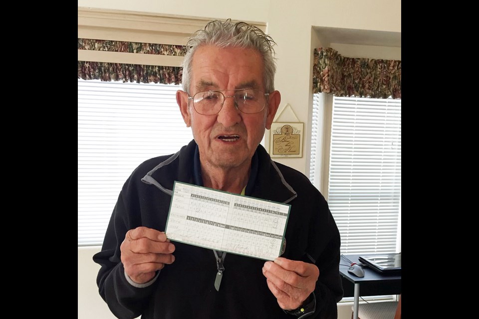 An 84-year-old Pete Sherba holds up his scorecard after scoring the 18th hole-in-one of his golfing career, Feb. 18, 2018 in Mesa, Ariz.