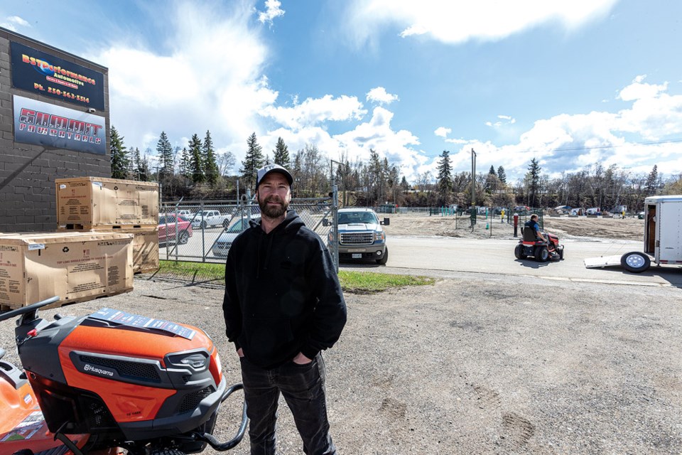 Steve Taylor, owner of Summit Powertools, looks over his inventory as a customer takes delivery of a lawn tractor in front of the construction taking place for the Third Avenue transition housing project.
