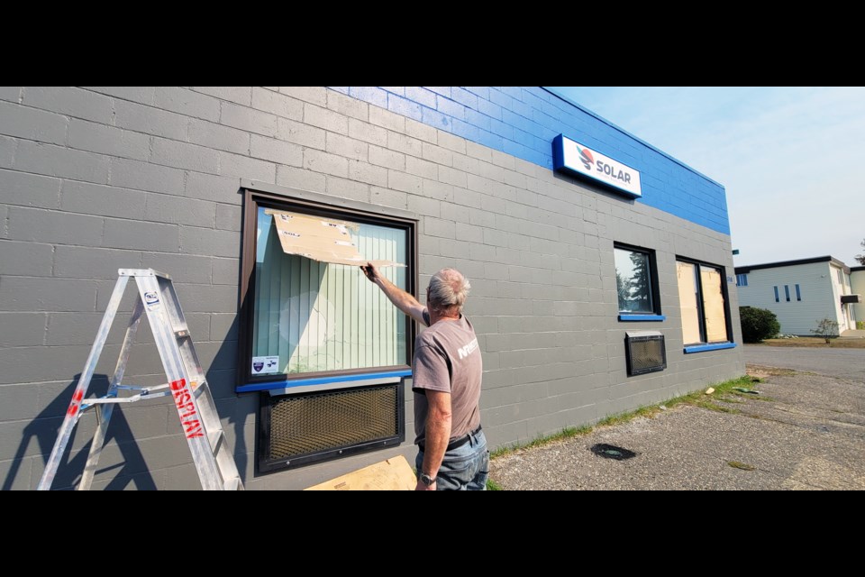 A worker at Solar Inflatable Boats on Third Avenue covers up the damage after the shop window were deliberately broken by a vandal early last Thursday morning.