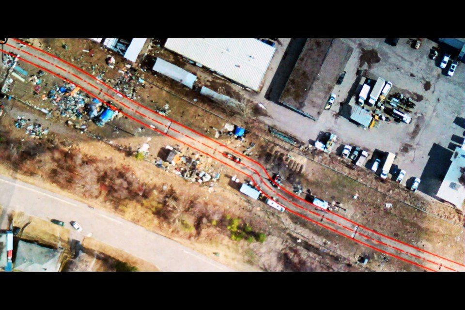 An aerial photo of the Moccasin Flats encampment along Lower Patricia Boulevard shows two solid red lines where the city plans to build a roadway on Monday.