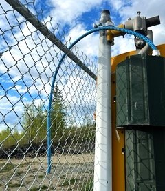 A wire dangles from tghe fence at PGARA Speedway which was part of the track lighting system before it was vandalized.