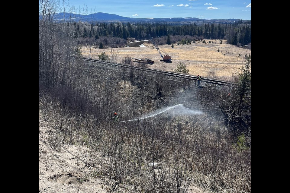 Volunteers douse a wildfire believed to have been caused by a passing train on April 14, 2024 near Endako, about 165 km northwest of Prince George.