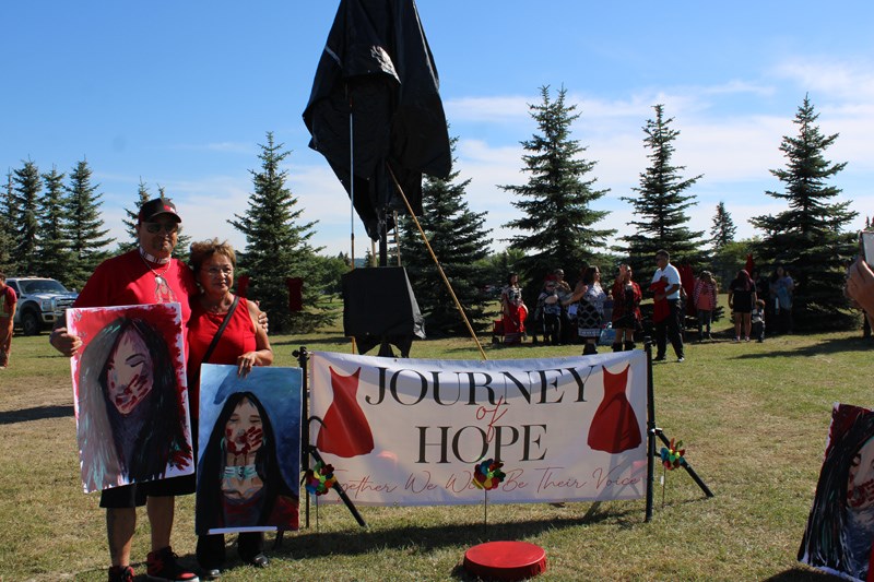 Drummer Wesley Mitchell stand with his auntie in front of the Journey of Hope banner. 