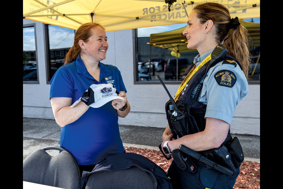 RCMP Cpl. Meghan Driscoll (left) and Cpl. Jennifer Cooper discuss the Tour de North ride while setting up a booth for Denny's Grand Slam Day to raise money for  Cops for Cancer. From 7 a.m .-2 p.m. Wednesday, proceeds from Denny's Grand Slam breakfasts sold will be donated to Tour de North which raises money for children and families living with cancer and beyond cancer.