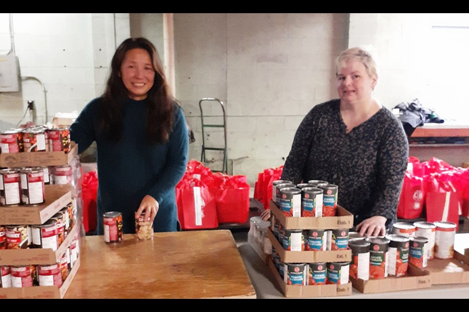 Rose Halsall, volunteer, left, and Michelle McGregor, executive director of the Prince George Council of Seniors, are part of the team preparing 165 Christmas hampers Tuesday morning for the Seniors Christmas Hamper project.