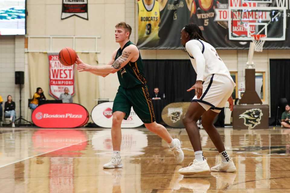 Josh Gillespie of the UNBC Timberwolves avoids the check of UBC's Alex Nwoye during Wednesday's Canada West playoff in Winnipeg. UNBC upset the T-birds 86-76.