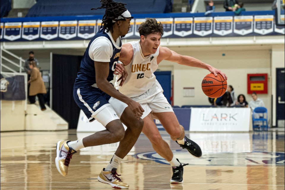 UNBC's Evgeny Baukin dribbles the ball out of the reach of UBC Thunderbirds defender Fareed Shittu during their Canada West game in Vancouver basketball on January, 11, 2025.