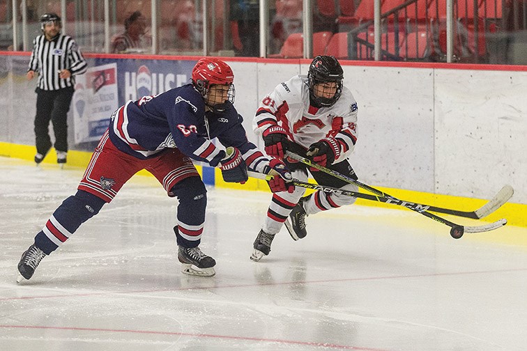 Citizen Photo by James Doyle. Cariboo U17AAA Cougars forward Isaiah Bagri and Greater Vancouver U17AAA Canadians defender Isaac Zed chase after the bouncing puck on Sunday morning in Kin 1 during B.C. Elite Hockey League U17AAA action.