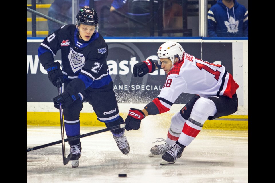 Victoria Royals forward Markus Loponen moves the puck around  Prince George Cougars checker Borya Valis in WHL action at the Save-on-Foods Memorial Centre in Victoria on Friday.